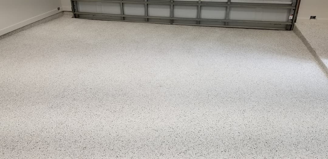 Epoxy-coated garage floor with a clean, polished finish and gray speckled design.