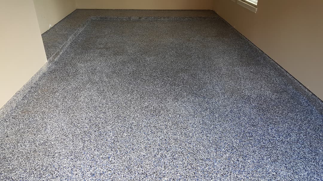 Newly installed epoxy flooring with a blue and gray speckled finish in a room.