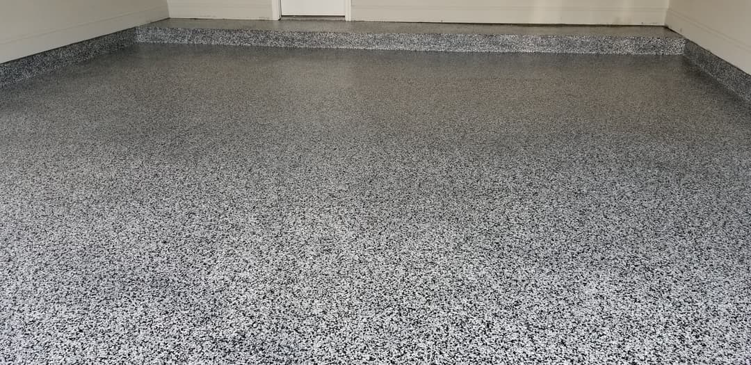 Epoxy-coated garage floor with a speckled gray finish and clean, smooth surface.