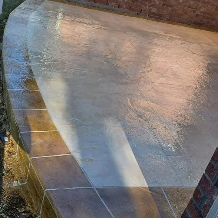 Sleek, newly finished concrete patio with a smooth surface and curved design.