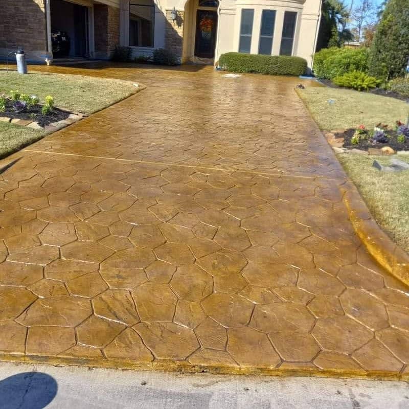 Decorative stamped concrete driveway with a hexagonal pattern and rich golden finish.