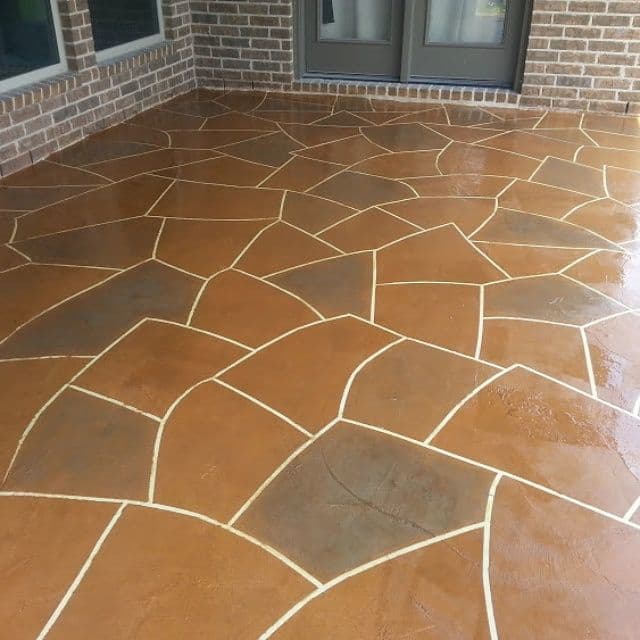Decorative stained concrete patio with intricate geometric pattern and contrasting grout lines.