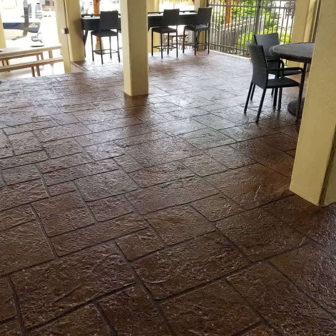 textured stamped concrete patio with outdoor seating area in a residential setting