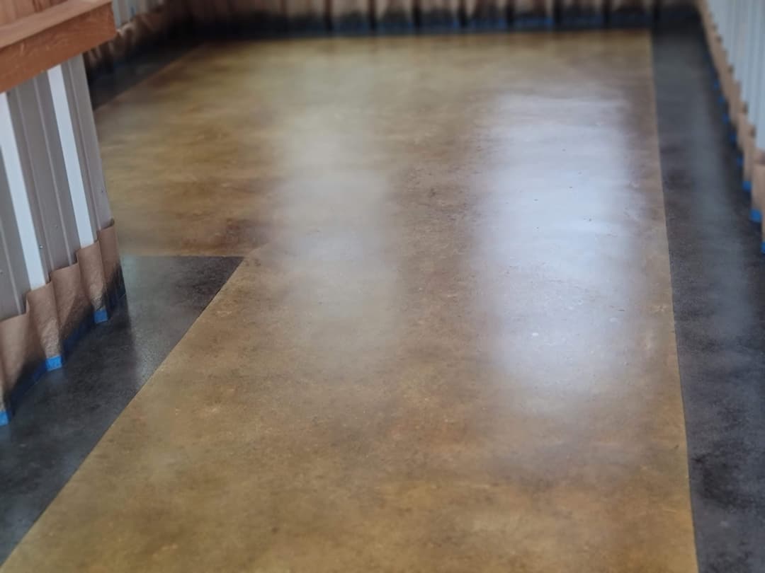 Polished concrete flooring in a modern space with tape outlining edges.