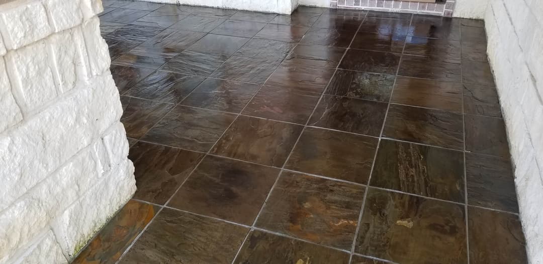 Polished slate floor with natural textures and colors in an entryway setting.