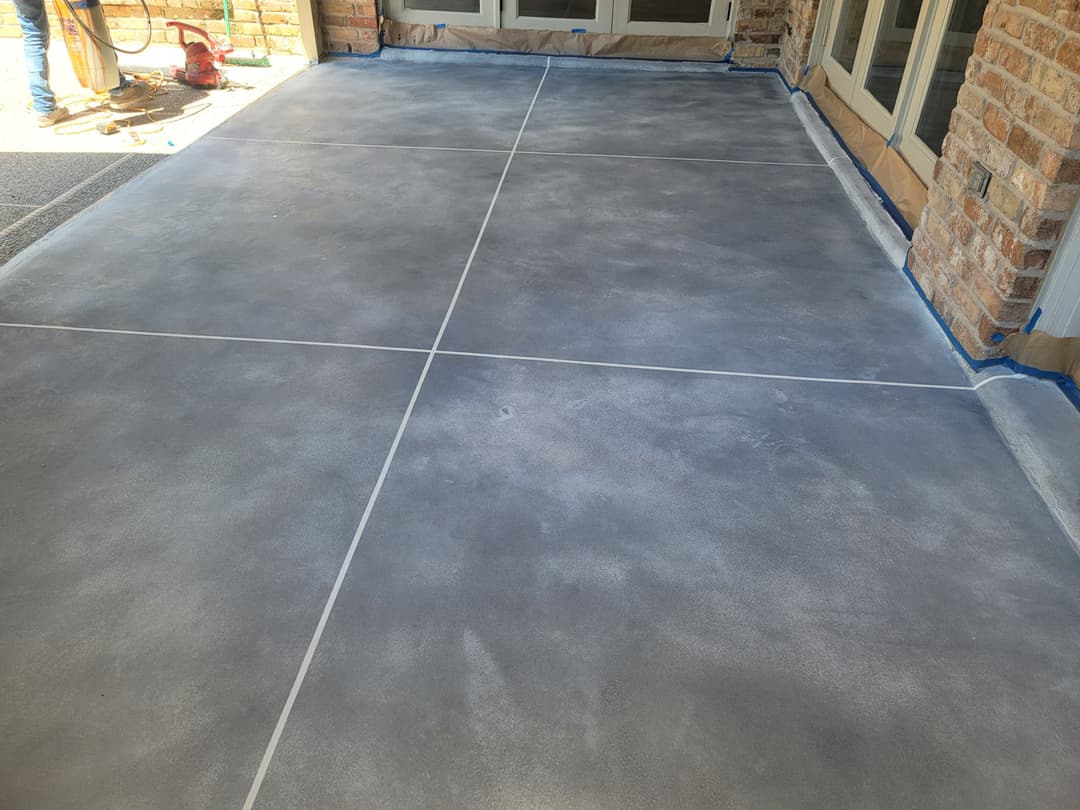 Freshly poured gray concrete patio with clean joints and smooth surface, ready for use.