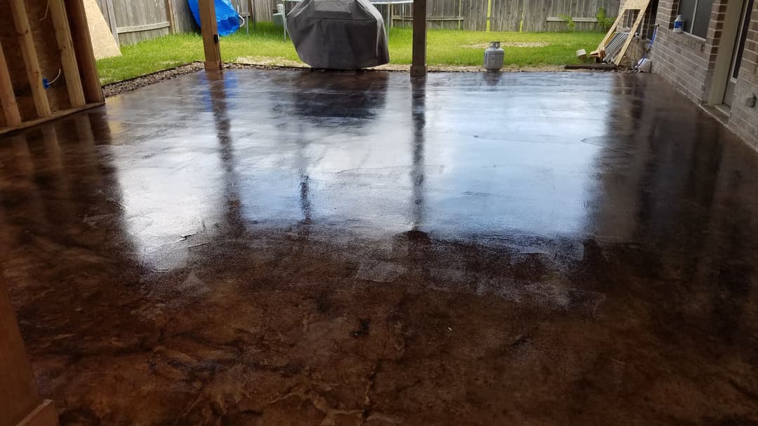 Shiny stained concrete floor in a covered outdoor area with green lawn.