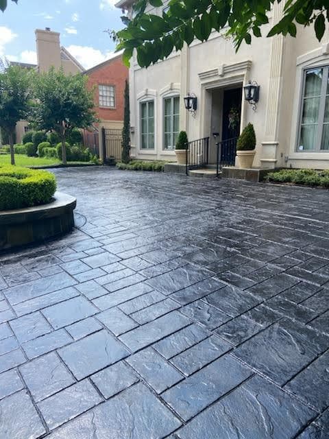 Stylish stamped concrete driveway leading to an elegant home with landscaped gardens.