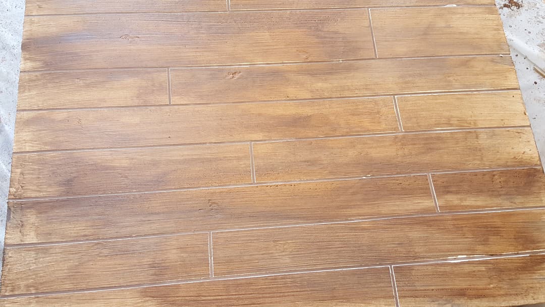 Wood-look tile flooring installation with a polished finish in a natural brown hue.