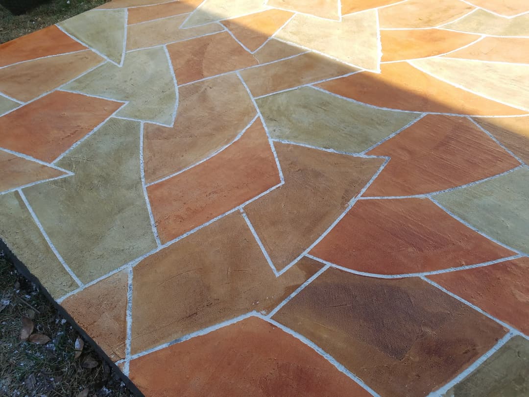 Colorful textured patio with a geometric pattern in warm shades of orange and beige.