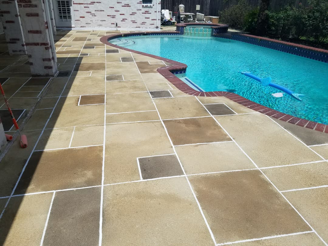 Poolside patio with stone tiles and clear blue water, featuring a float and clean grout lines.