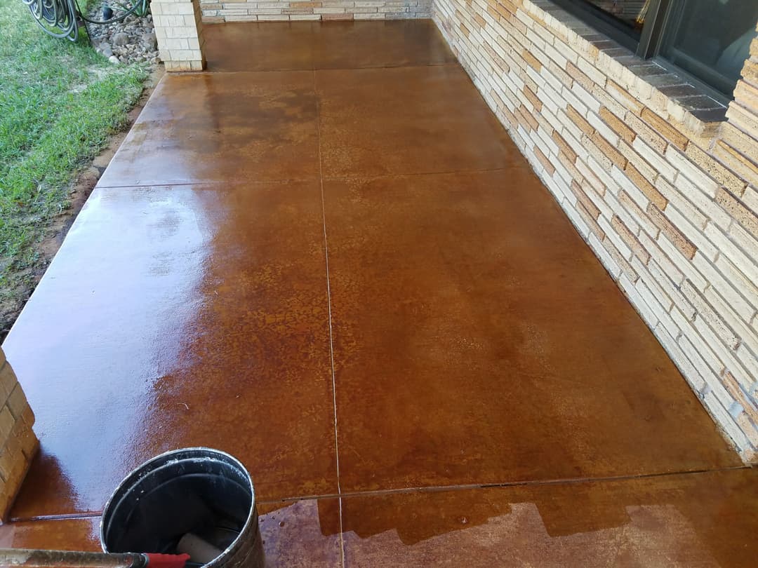 Stained concrete patio with a rich brown finish and a clean, polished surface.