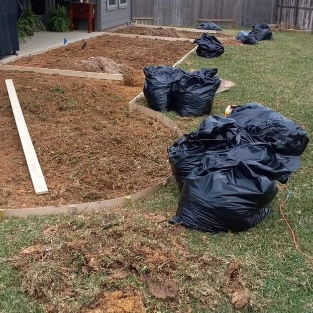Garden preparation with soil bags and an outline for a new landscaping project.