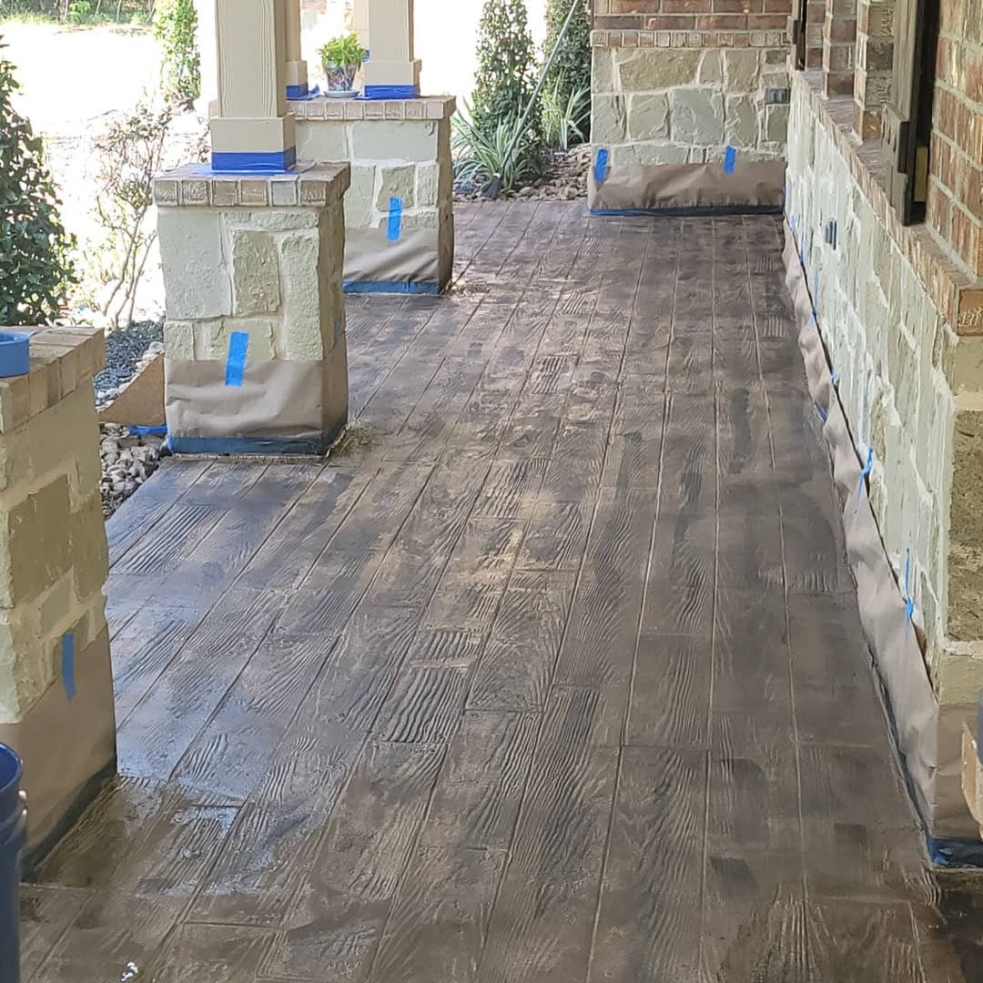Newly finished wooden porch with stone pillars and protective tape along the edges.