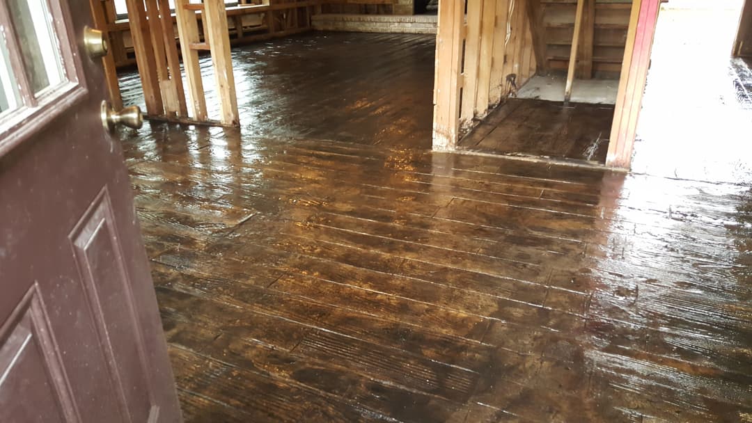 Refinished wooden floors in an interior space with partially framed walls and doorway.
