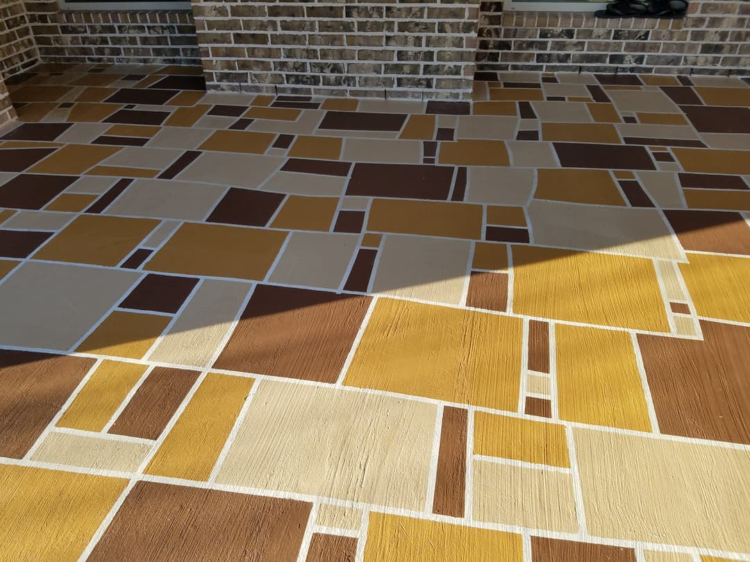 Colorful patterned patio with yellow, brown, and beige geometric tiles.