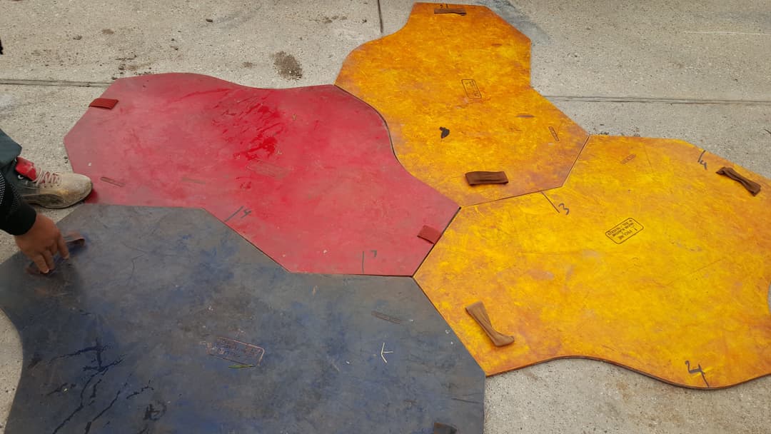 Colorful interlocking rubber mats in red, blue, and yellow arranged on a concrete surface.