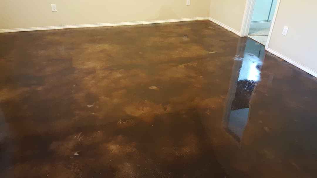 Polished brown epoxy floor in a spacious interior room with neutral walls.
