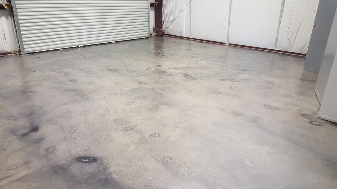 Polished concrete floor in a spacious industrial warehouse with overhead door.