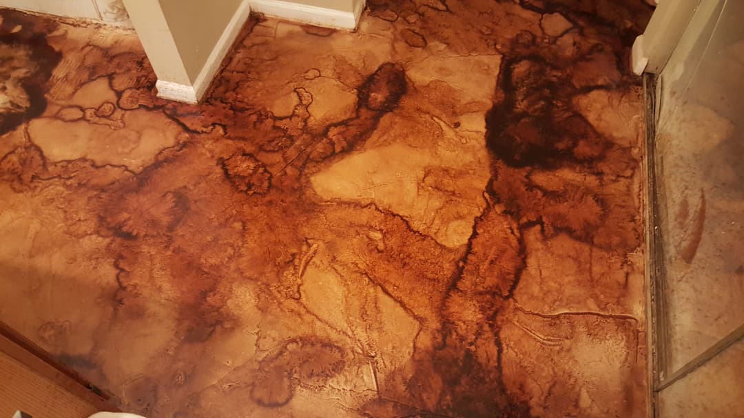 Decorative stained concrete floor with rich brown and tan patterns in residential interior.