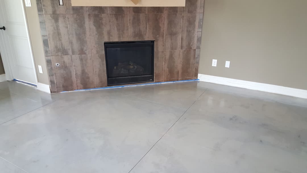 Modern living room with polished concrete floor and tiled fireplace accent wall.