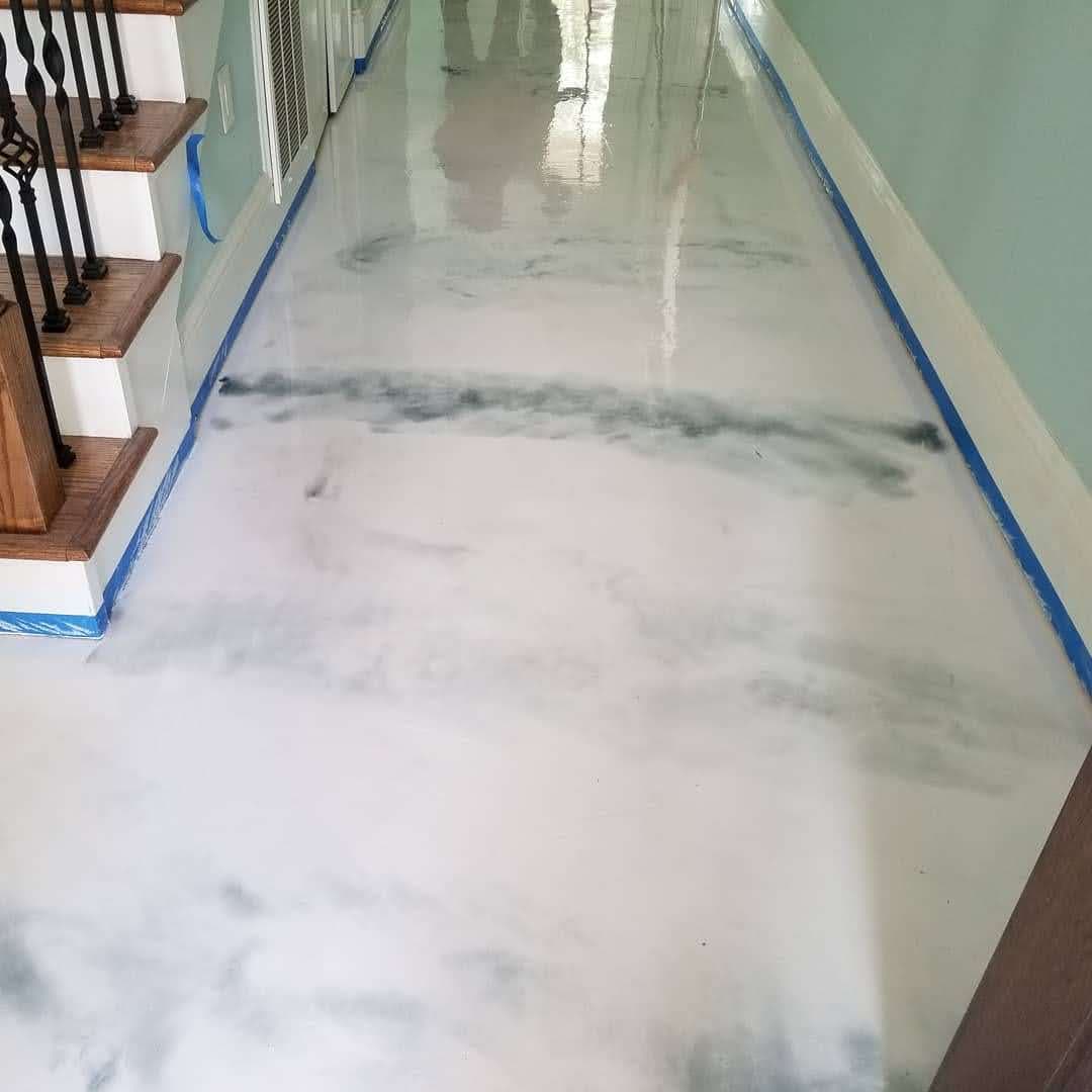 Marble-effect epoxy floor in modern interior with staircase and blue accents.