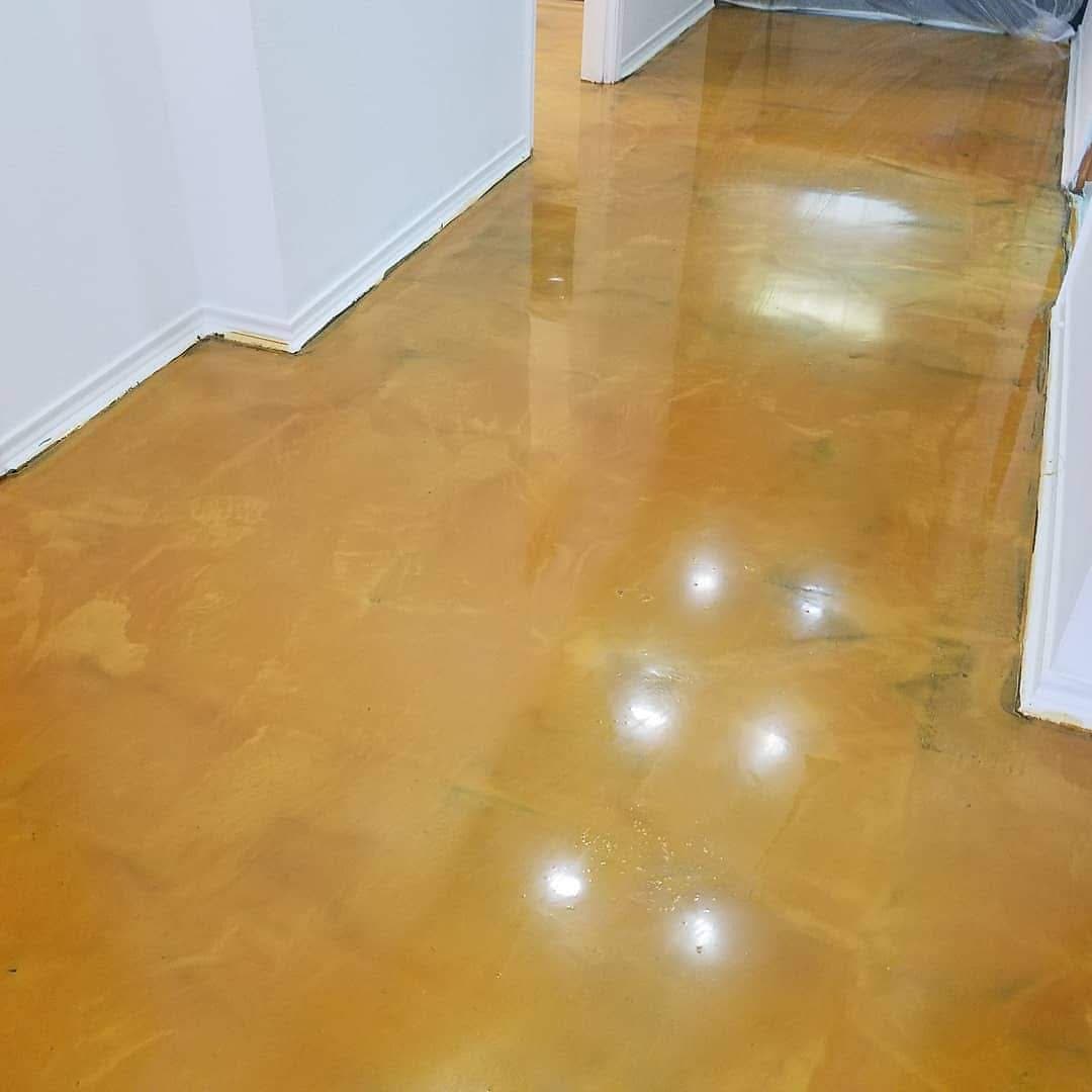 Shiny polished concrete floor in a hallway with white walls and doorways.