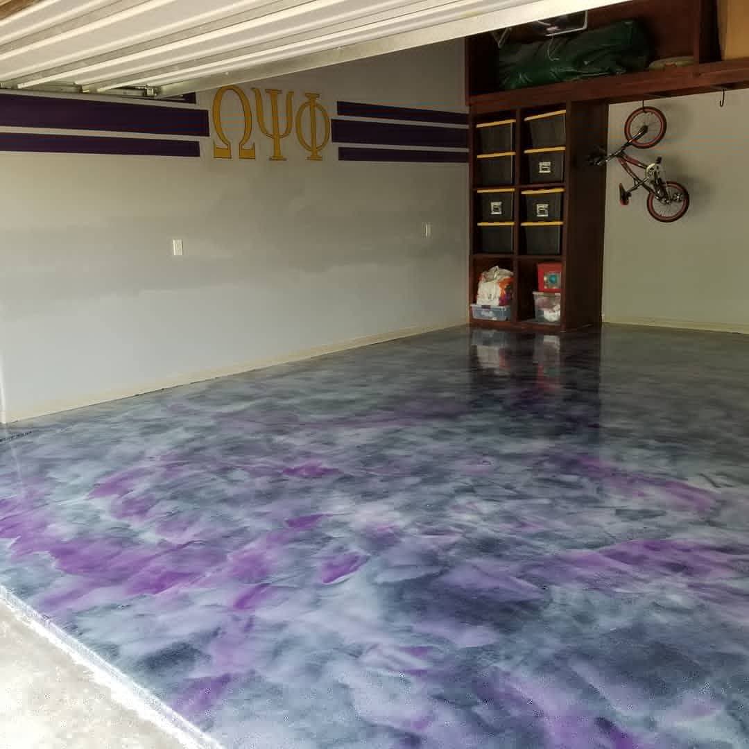 Epoxy garage floor with purple and black swirls, featuring decorative wall details and storage.