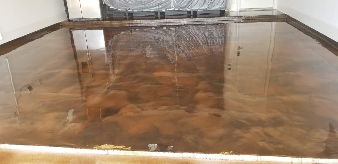 Polished epoxy floor showcasing a glossy brown finish in a well-lit interior space.