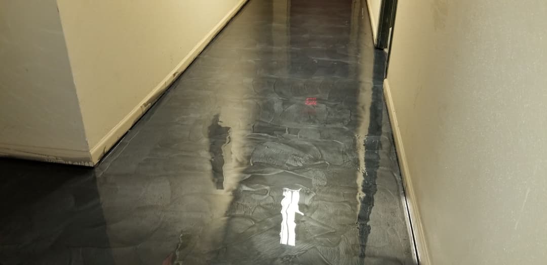 Shiny epoxy floor in a narrow hallway with smooth, glossy finish.
