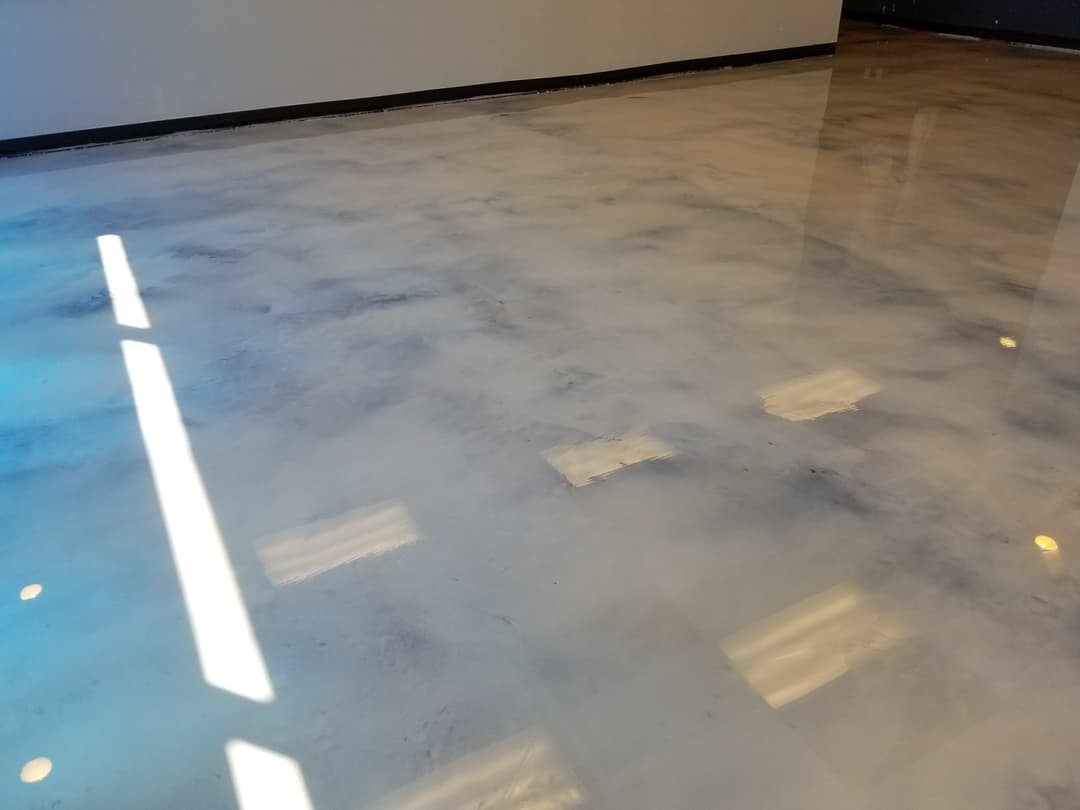 Polished concrete floor with a reflective surface and natural light highlights.