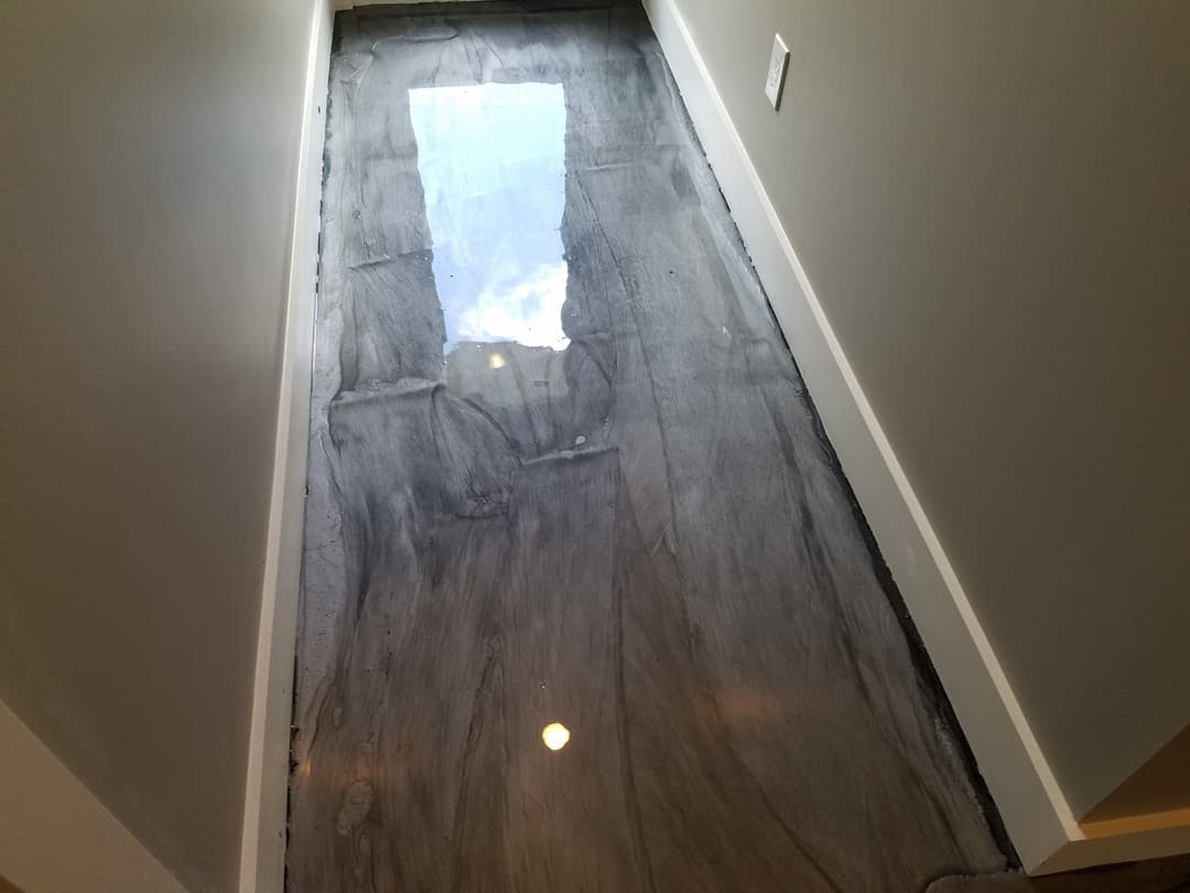 polished concrete floor with a marbled gray design reflecting ceiling lights and windows