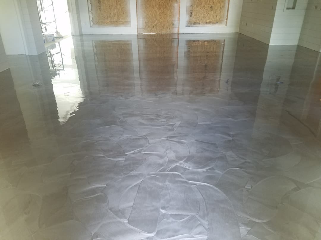 Polished concrete floor with a textured design in an unfinished interior space.