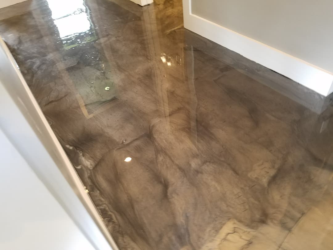 Glossy epoxy resin floor in a modern hallway reflecting light and surroundings.