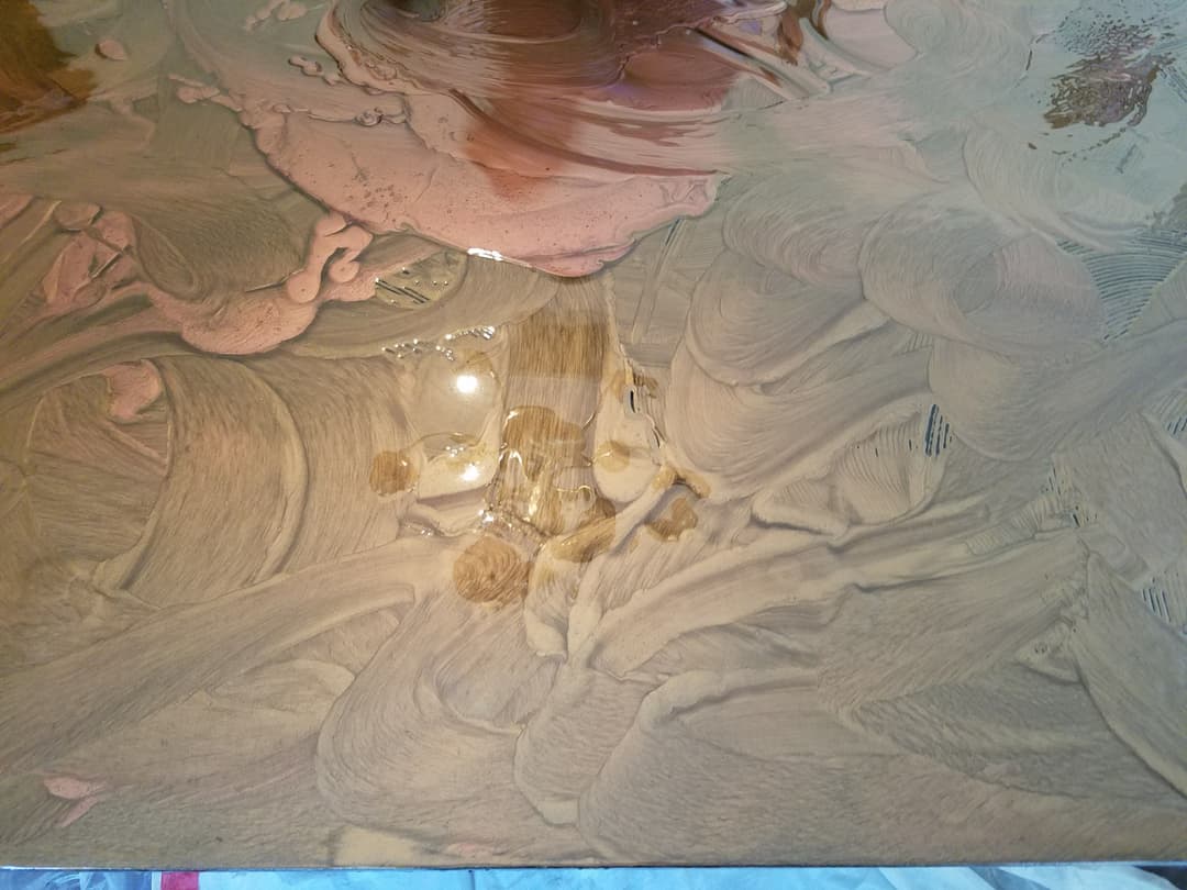 Close-up of textured resin surface with swirls and reflections, showcasing artistic detail.