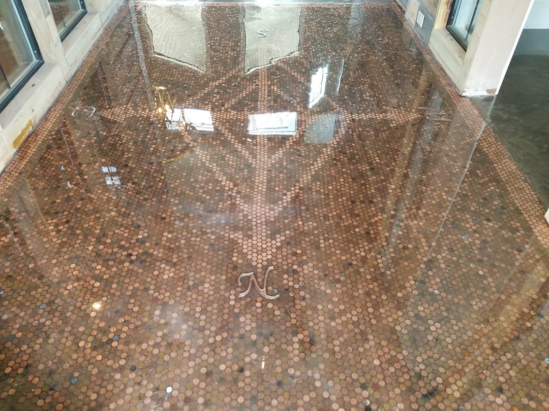 Unique penny floor design with reflections and intricate patterns in a stylish interior.
