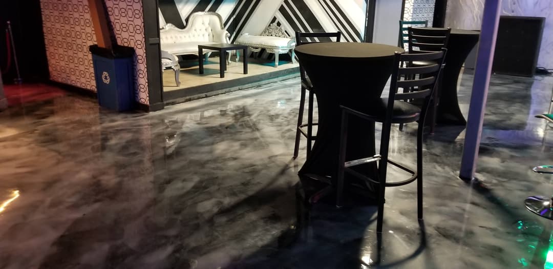 Stylish lounge area with modern seating and glossy black and white floor design.