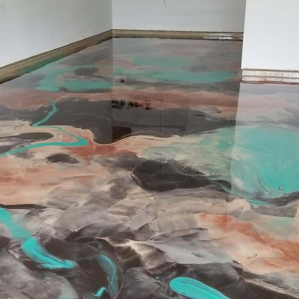 Epoxy resin floor with abstract patterns in brown, black, and turquoise colors.