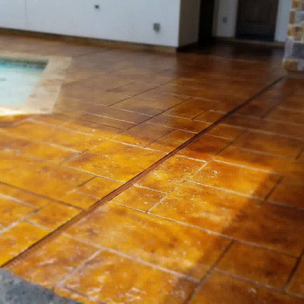 Stained concrete patio with pool, featuring warm tones and a textured finish.